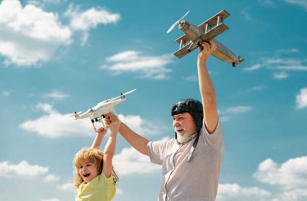 Foto abuelo e hijo con avión y dron quadcopter sobre cielo azul y fondo de nubes hombres generación abuelo y nieto pariente anciano con hijo