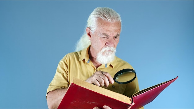 Foto alter mann, der buch mit vergrößerungsglas-foto betrachtet
