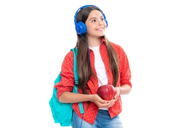 Foto aluna adolescente colegial em fones de ouvido segura livros sobre fundo branco de estúdio isolado conceito de educação musical e escolar de volta à escola retrato de uma adolescente sorridente feliz