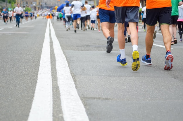 Foto carrera de maratón muchos pies de los corredores en la competencia deportiva de carreras de carretera fitness y vida saludable