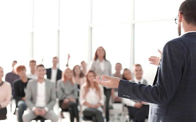 Foto cerrar orador de pie frente a la audiencia en la sala de conferencias