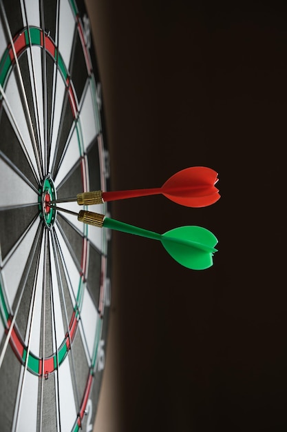Foto concepto de competencia y logro de metas logro de metas en los negocios y la vida tablero de dardos con dos dardos clavados en el centro derecho del objetivo