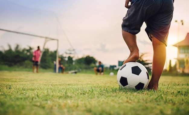 Foto deporte de acción al aire libre de un grupo de niños que se divierten jugando fútbol