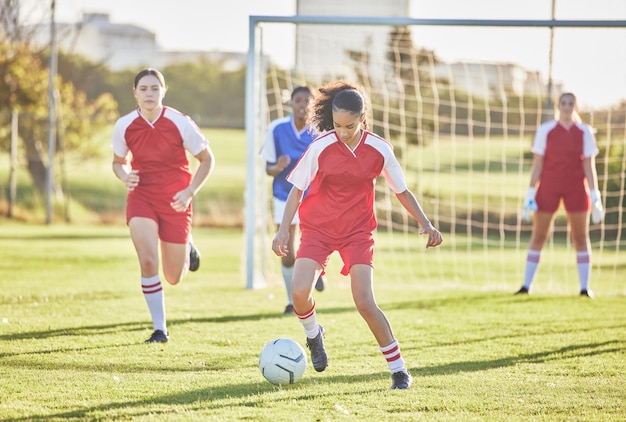Foto deportes de fútbol femenino y equipos de niñas jugando partidos en el campo mientras patean, taclean y corren con una pelota jugadores de fútbol hábiles y rápidos de energía en un juego competitivo contra oponentes al aire libre