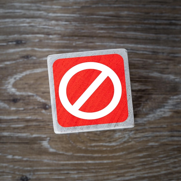 Foto ein rotes stoppschild-symbol oder -symbol auf einem holzblock und einem hölzernen hintergrund mit kopierraum