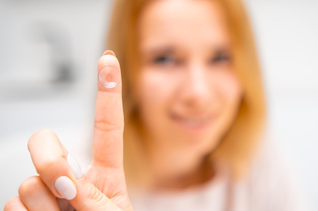 Foto eine frau hält eine kontaktlinse am finger