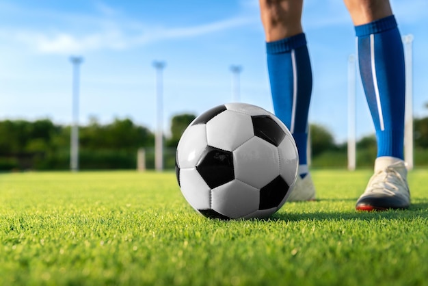 Fußballspieler setzen Ballfußball für Kick-Free-Kick-Shooting oder Kick, um eine Punktzahl im Grasstadion zu gewinnen