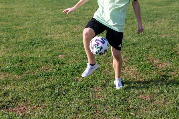 Foto fútbol estilo libre. joven practica con balón de fútbol. jugador que entrena los trucos básicos con el balón.