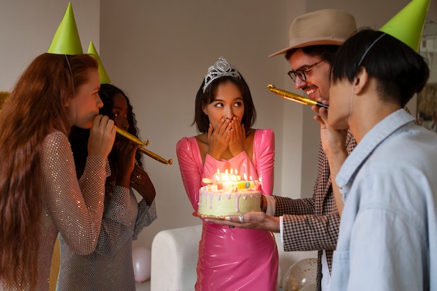 Foto grupo de amigos con pastel en una fiesta sorpresa de cumpleaños