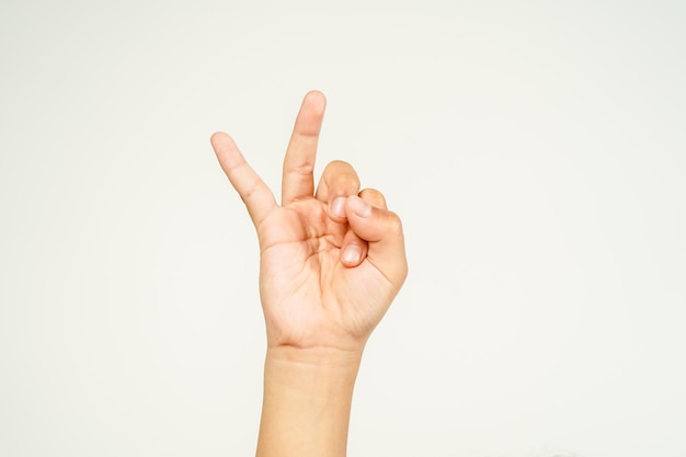 Foto hand eines kindes zeigt mit zwei fingern ein friedenszeichen, das auf weißem hintergrund isoliert ist