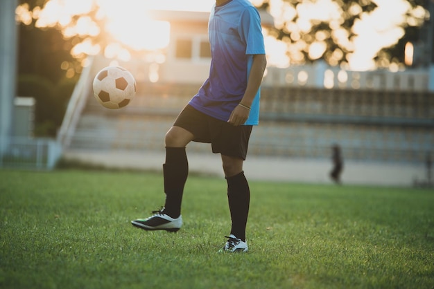 Foto hombre jugando al fútbol en el césped
