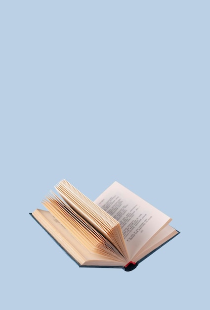 Foto libro abierto en una cubierta azul en un espacio de copia de fondo azul
