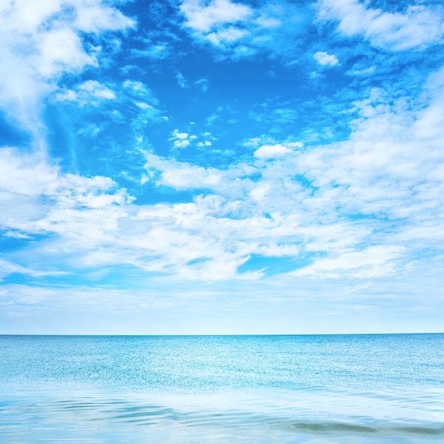 Foto mar azul claro e céu com nuvens brancas