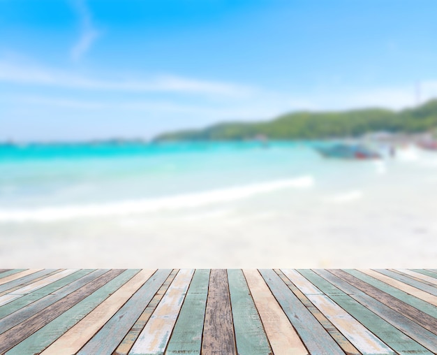 Foto mesa de madera con escena de naturaleza borrosa playa tropical y cielo azul, concepto de fondo de vacaciones - se puede utilizar para mostrar o montar sus productos