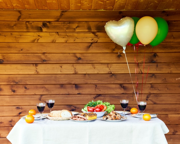 Foto mesa llena de verduras y carne globos de aire en madera