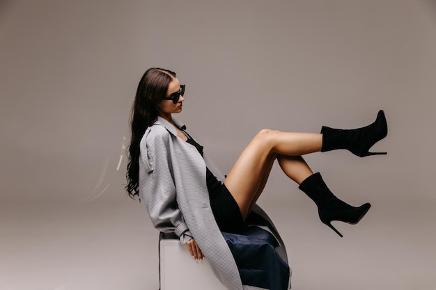 Foto modelo posando em modelo de estúdio em casaco preto e sapatos
