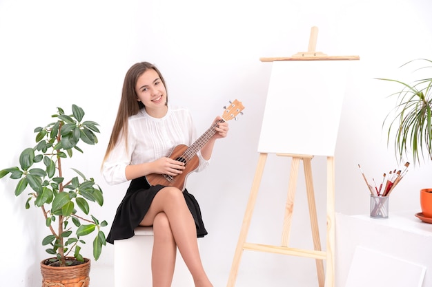 Mujer joven con guitarra sobre fondo blanco con espacio de copia