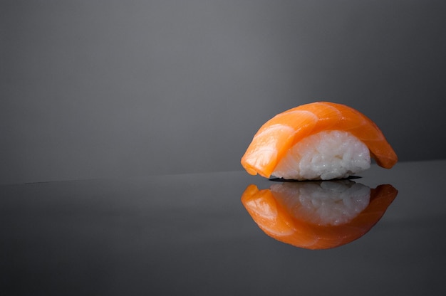 Foto nahaufnahme von sushi mit reis auf grauem hintergrund mit reflektion