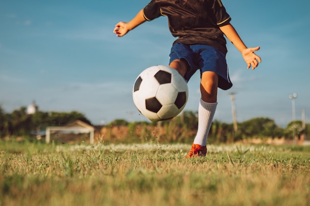 Foto niños jugando al fútbol para hacer ejercicio en el campo de hierba verde
