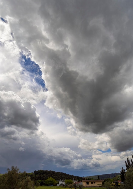 Foto nuvens cumulus gigantes antes da tempestade de verão que se aproxima em uma vila na ilha na grécia