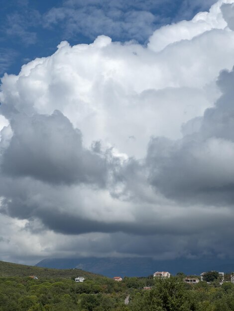 Foto nuvens de trovão pairam baixas sobre as casas nas montanhas.