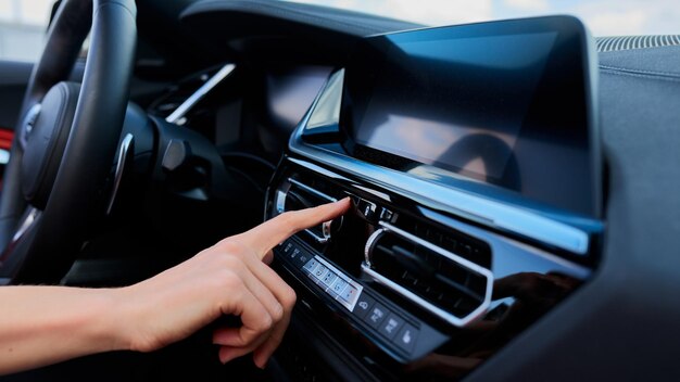 Foto o conceito de uma condutora feminina a mão feminina que aperta o botão de emergência no carro botões em um carro moderno