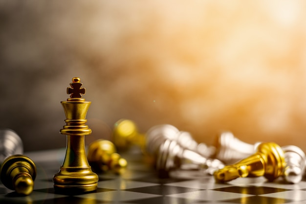 O rei de ouro do xadrez em pé encontra derrotar os inimigos.