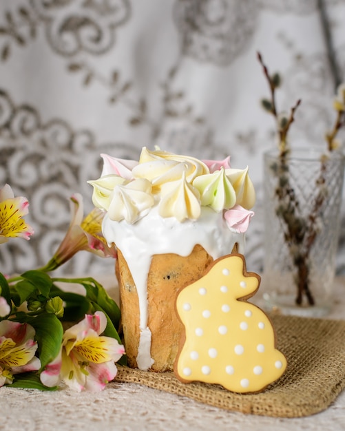 Osterkuchen mit gelbem Baiser und gelbem Lebkuchen in Form eines Hasen für die Osterfeier verziert