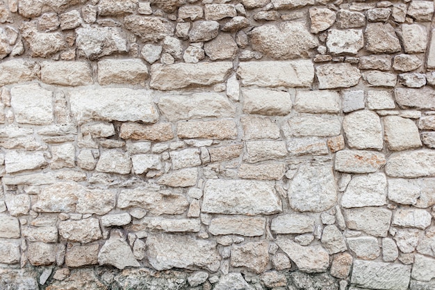 Foto pared de roca de piedra rugosa beige. textura, estilo antiguo, fondo