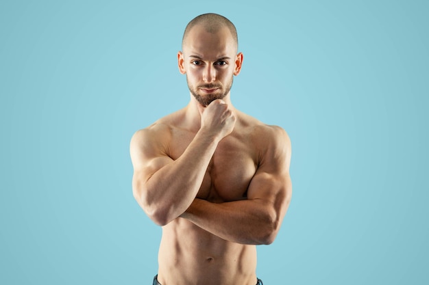 Foto pensando homem atlético careca olhar sério para a câmera enquanto tendo pensamentos sobre dieta de fitness
