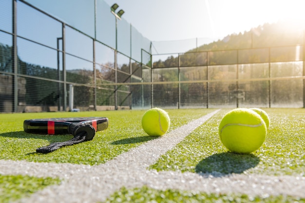 Foto pista de pádel al aire libre con raqueta y pelotas