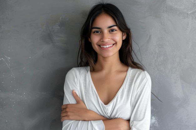 Porträt einer jungen lateinischen Frau mit gekreuzten Armen, die lächelt