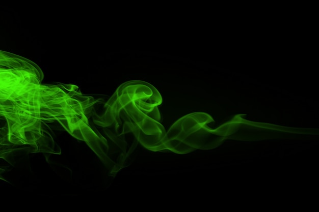 Resumen de humo verde sobre negro y concepto de oscuridad