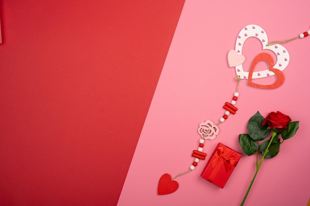 Foto romantiker roter und rosa hintergrund mit holzherz-kleider, rote geschenkkiste, weiße rosen
