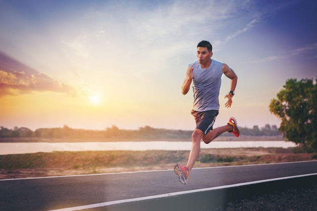 Foto silueta de hombre corriendo corriendo en carretera. corredor masculino apto de la aptitud durante entrenamiento al aire libre