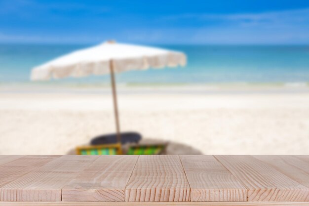Foto sobremesa de madera en el mar azul borroso y el fondo blanco de la playa de la arena