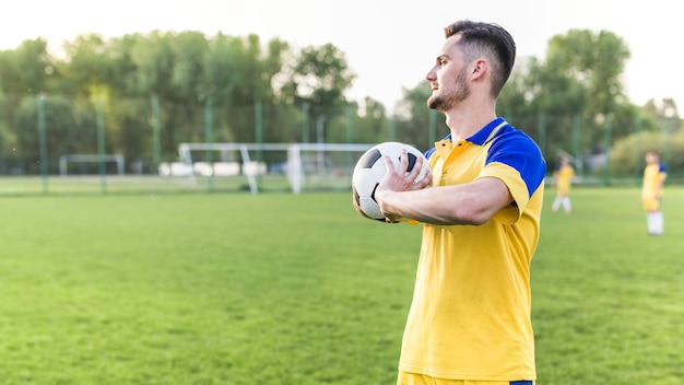 Foto gratuita concepto de fútbol de amateur con hombre posando con pelota