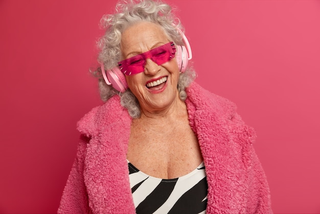 Foto gratuita close up retrato de abuela de moda arrugada feliz vistiendo abrigo y medias rosa