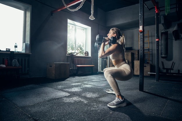 Foto gratuita la atleta femenina entrenando duro en el gimnasio. concepto de fitness y vida sana.