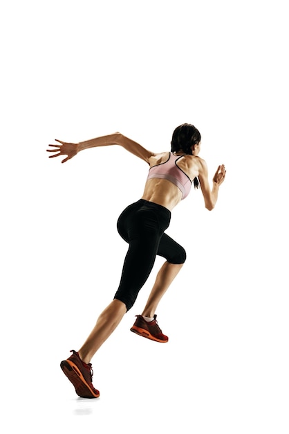 Foto gratuita atleta profesional femenina en entrenamiento uniforme corriendo aislada sobre fondo blanco de estudio