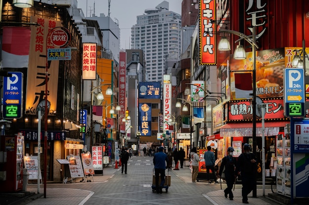 Foto gratuita gente caminando por la calle de japón por la noche