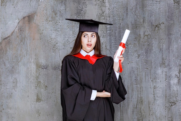 Foto gratuita foto de una estudiante con bata posando con certificado de graduación. foto de alta calidad