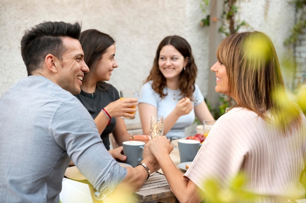 Foto gratuita familia almorzando juntos al aire libre