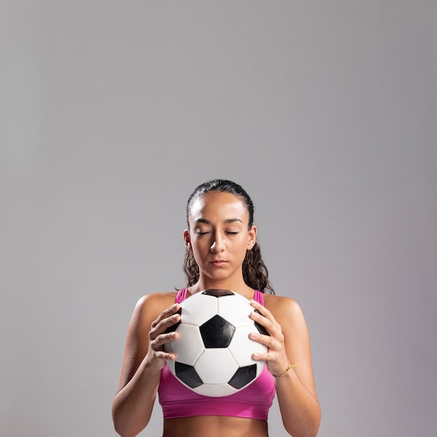 Foto gratuita fit mujer sosteniendo el balón de fútbol