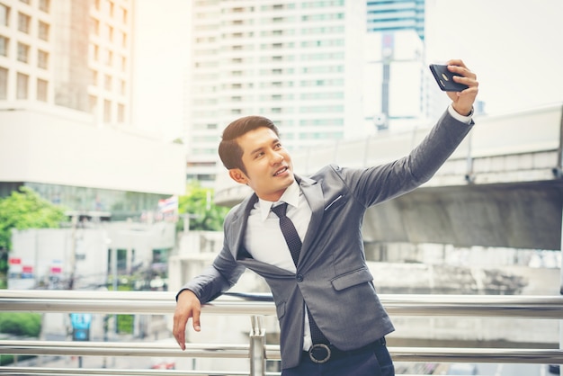 Foto gratuita hombre de negocios que toma selfie del teléfono afuera.