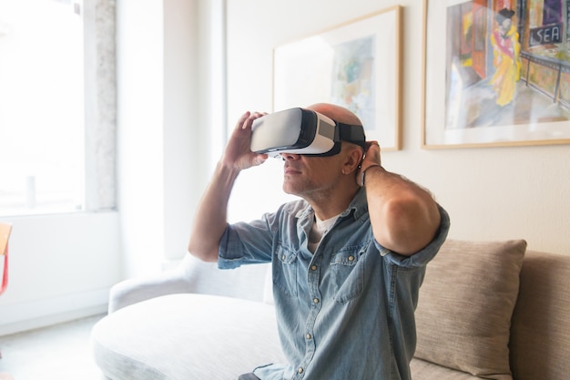 Foto gratuita hombre calvo disfrutando de la experiencia de realidad virtual en casa