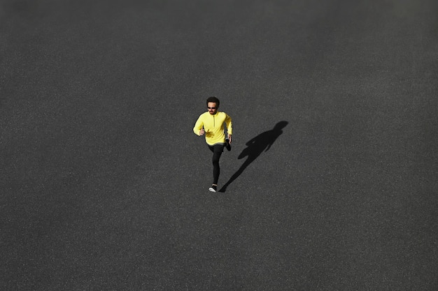 Foto gratuita hombre de corredor de vista superior corriendo en la carretera