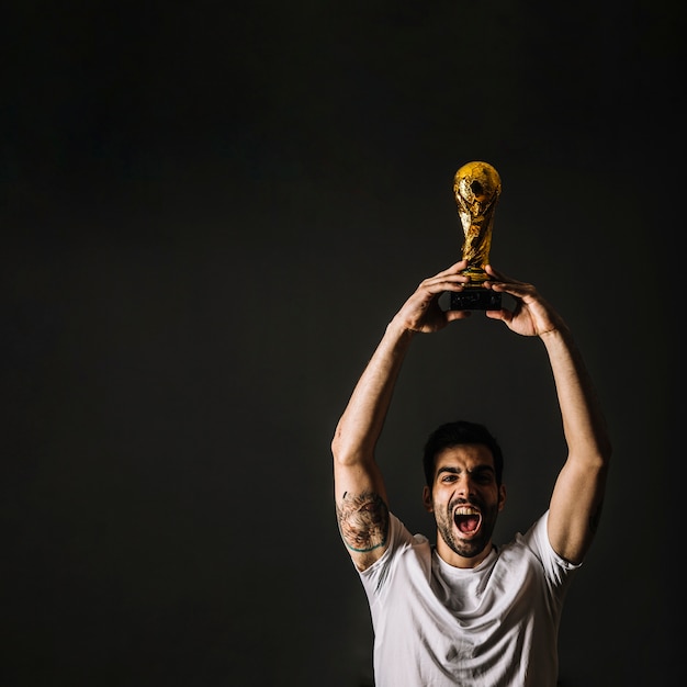 Hombre con el trofeo de la FIFA celebrando la victoria