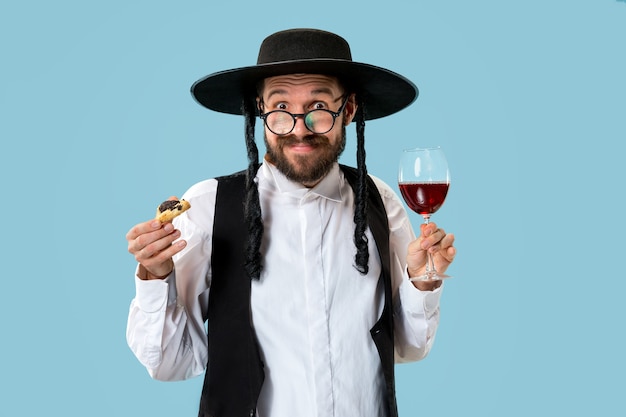 Foto gratuita el joven judío ortodoxo con sombrero negro con galletas hamantaschen para la fiesta judía de purim