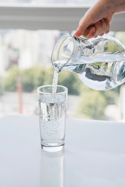 Foto gratuita jarra llenando vaso de agua